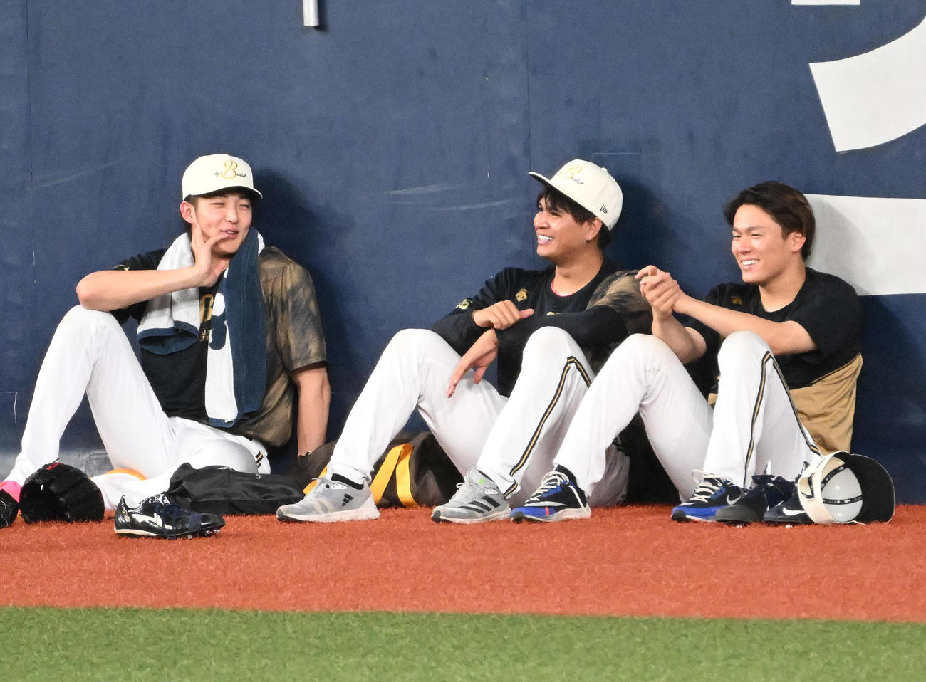 練習後、フェンス際に座り込んで談笑する山崎颯一郎、宇田川優希、山本由伸（2023年4月撮影）