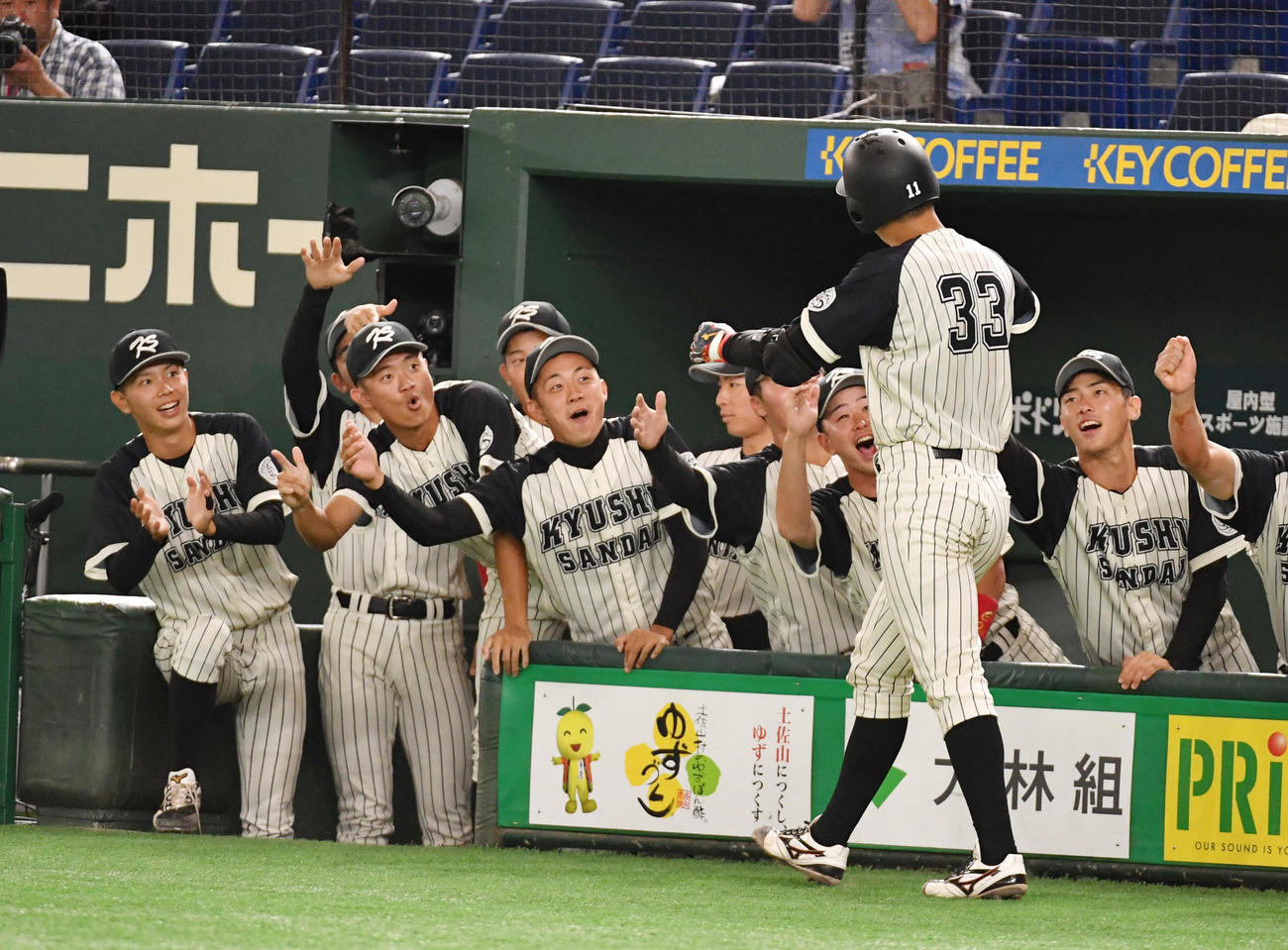 九産大対中部大　4回表九産大1死、菊池は左越えに本塁打を放ちナインの出迎えを受ける（撮影・柴田隆二）