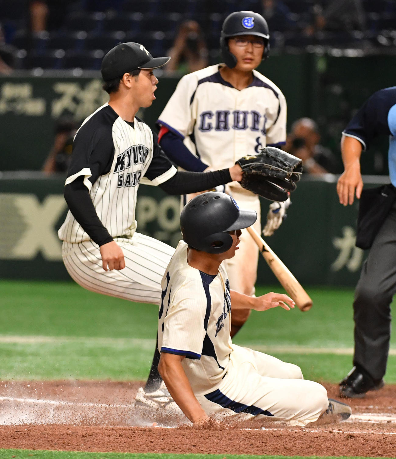 九産大対中部大　6回裏中部大2死三塁、打者川口の時、江越（左）の暴投で三塁走者田沢が生還する（撮影・柴田隆二）