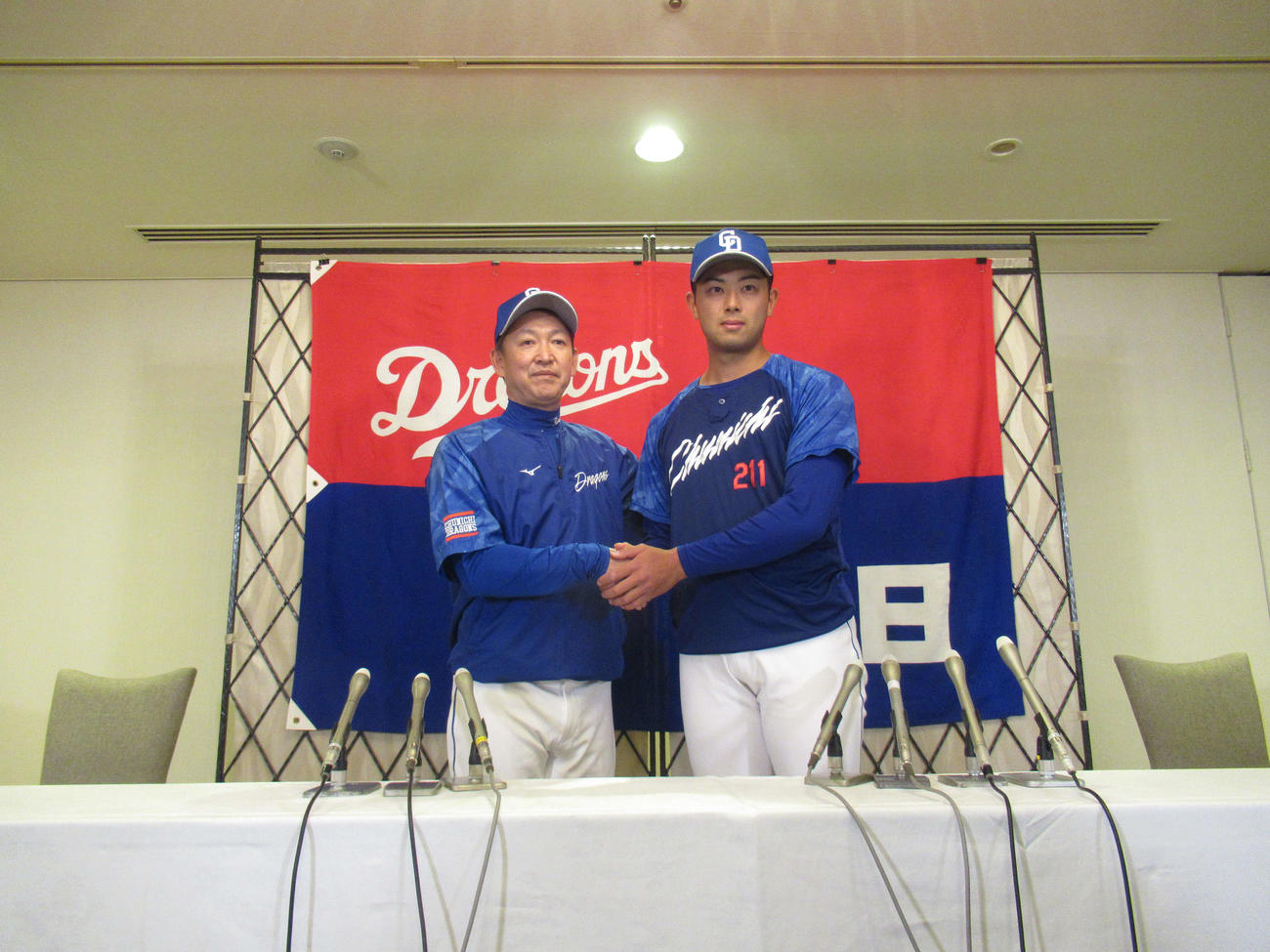 会見で立浪監督とがっちり握手をする中日松山