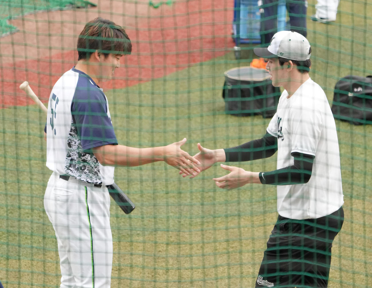 ロッテ対ヤクルト　試合前の練習であいさつするヤクルト村上（左）とロッテ佐々木朗（撮影・小沢裕）