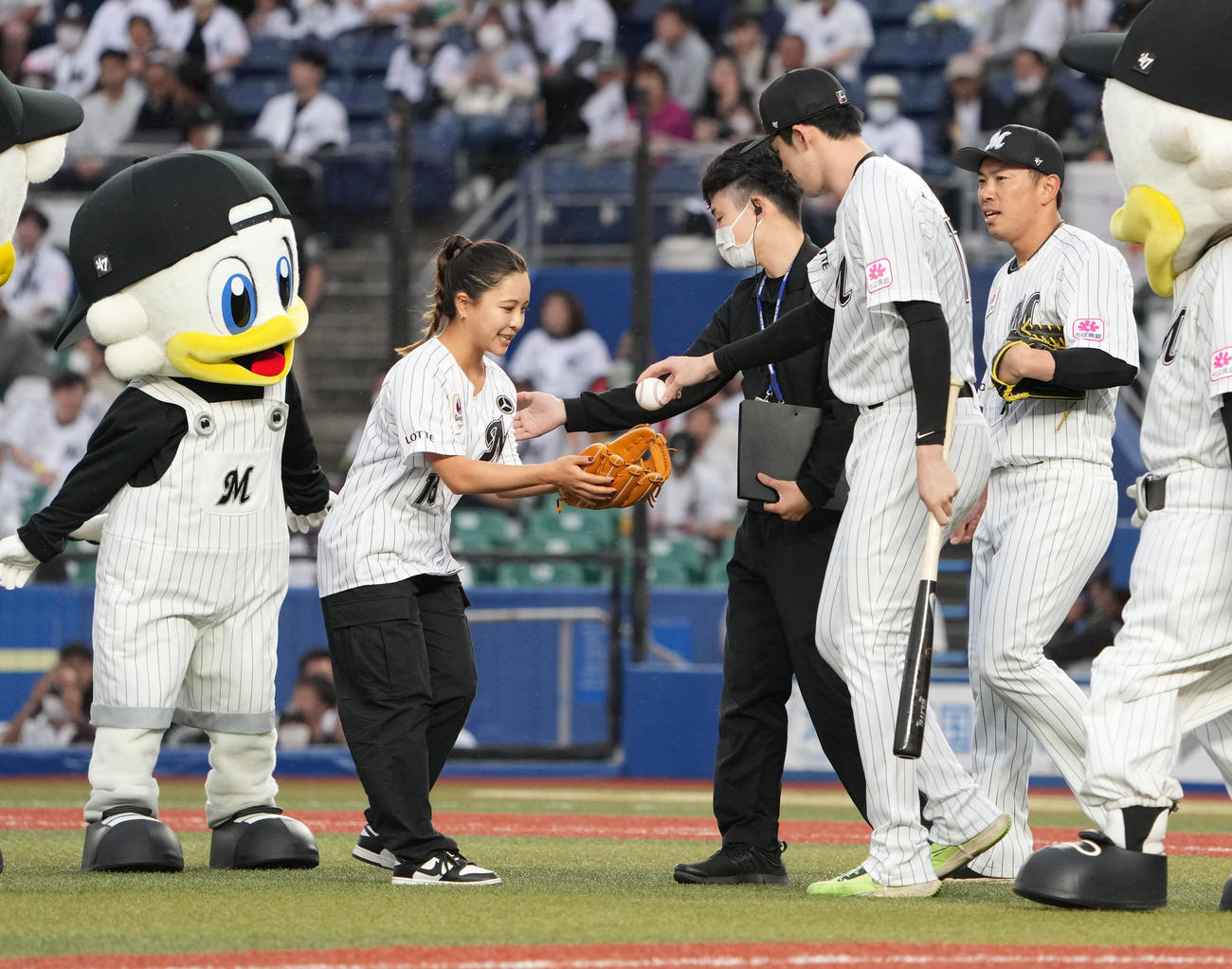 ロッテ対ヤクルト　始球式を行った女子スキージャンプの高梨（左）はロッテ佐々木朗から記念球を手渡される（撮影・小沢裕）