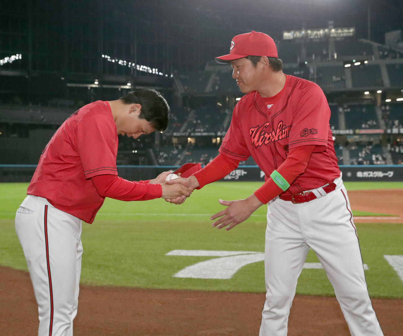 日本ハム対広島　プロ初勝利を挙げた広島栗林（左）は新井監督と握手をする（撮影・佐藤翔太）