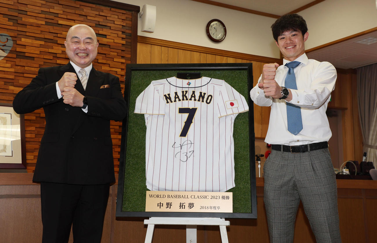 東北福祉大から特別功労賞を授与され、サイン入りユニホームを贈呈した中野は千葉公慈学長（左）とともにペッパーミルポーズで笑顔を見せる（撮影・加藤哉）