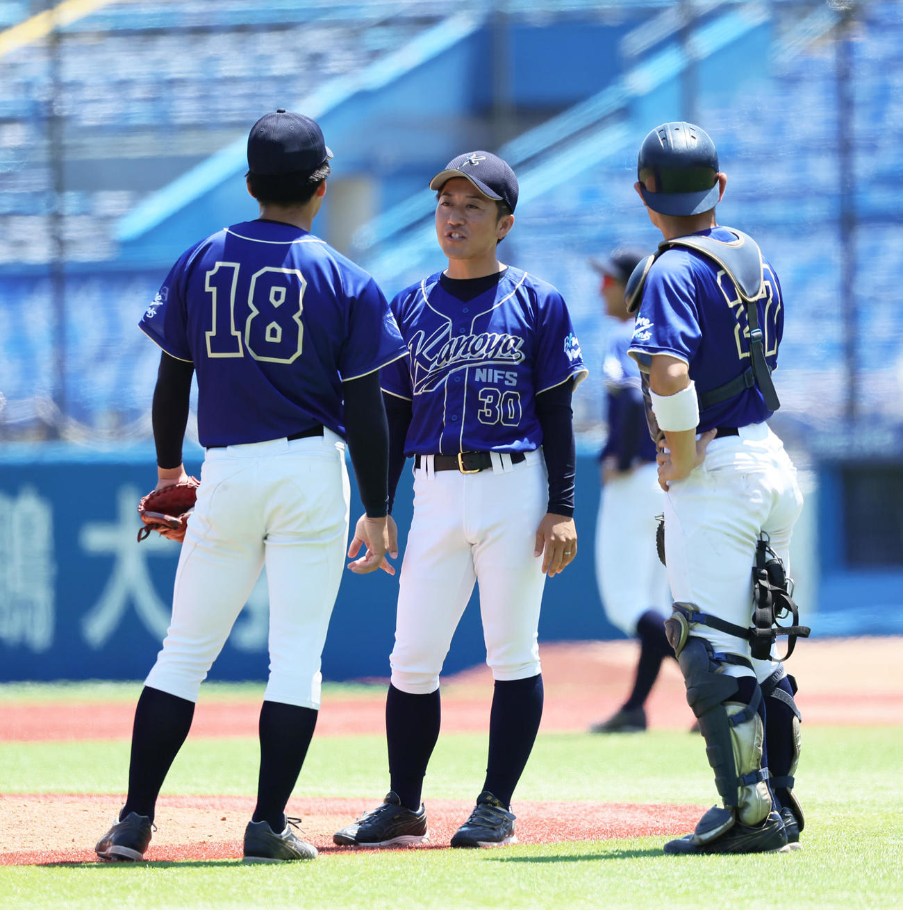 近大対鹿屋体大　マウンドで鹿屋体大バッテリーに声をかける藤井監督（中央）（撮影・足立雅史）
