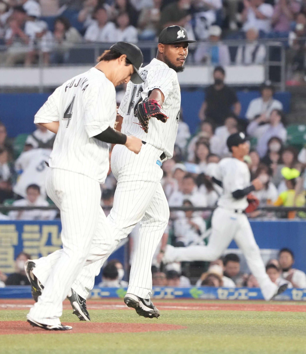 ロッテ対ヤクルト　3回表ヤクルト2死、ロッテ先発のメルセデスは山田の打球を処理した藤岡(左)にグラブタッチを求める（撮影・小沢裕）