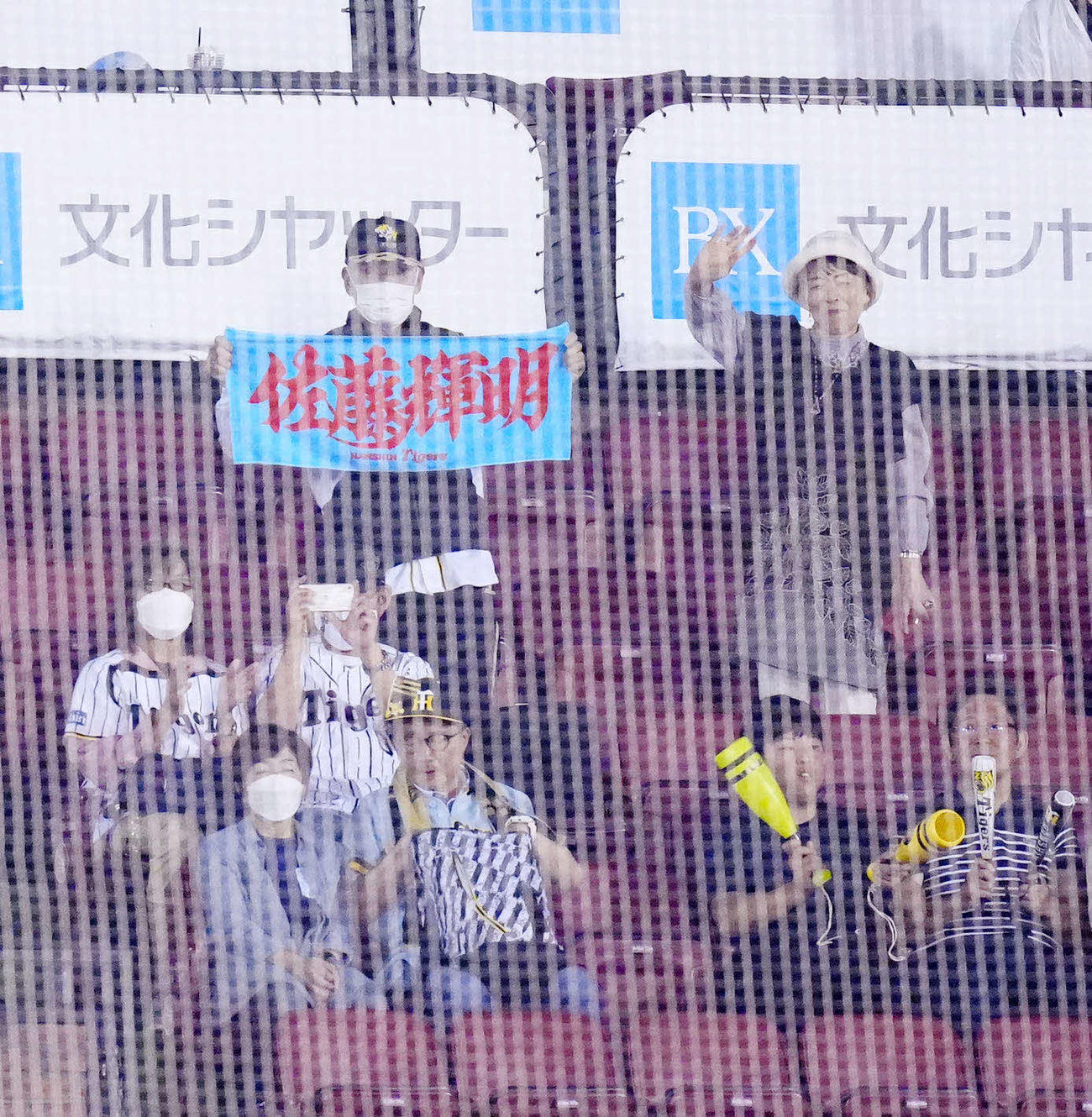 楽天対阪神　試合後、阪神佐藤輝の応援タオルを手にする祖父勲さん（上段左）と手を振る祖母美智恵さん（撮影・江口和貴）