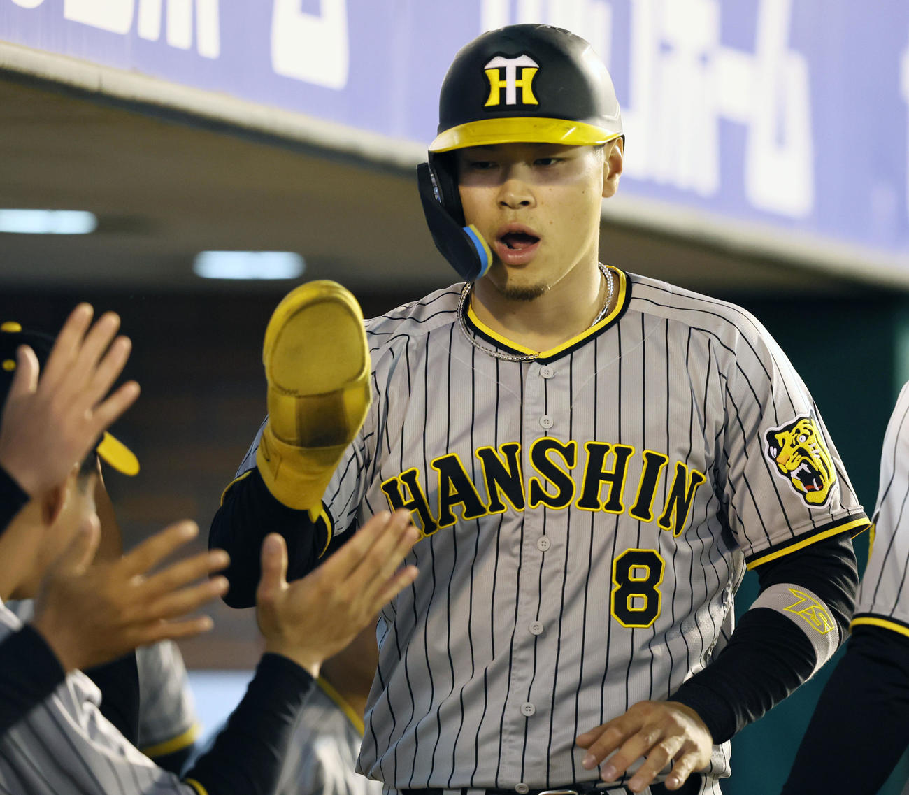 楽天対阪神　5回表阪神1死三塁、三塁走者佐藤輝は梅野の右適時打で生還しベンチのナインとタッチする（撮影・加藤哉）
