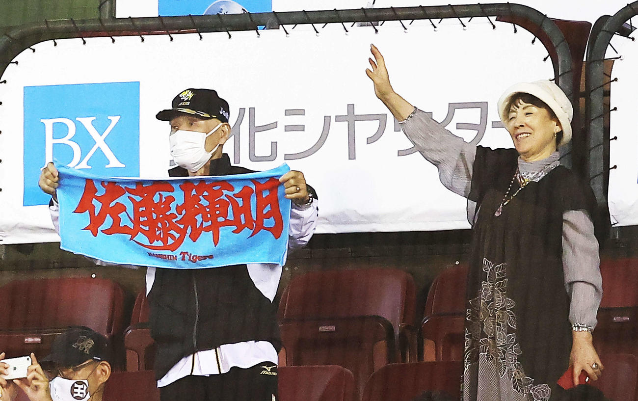楽天対阪神　試合後、阪神佐藤輝のヒーローインタビューでタオルを掲げる祖父の勲さん（左）と手を振る祖母の美智恵さん（撮影・河田真司）