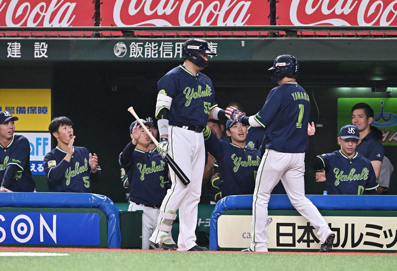 西武対ヤクルト　1回表ヤクルト無死三塁、青木の先制中前適時打から生還した山田（手前右）とタッチをかわす村上（撮影・滝沢徹郎）