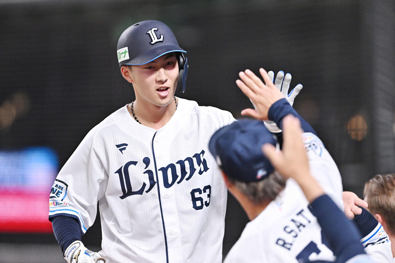 西武対ヤクルト　2回裏西武無死、左越えソロ本塁打を放った長谷川（左）は生還しチームメートとタッチをかわす（撮影・滝沢徹郎）