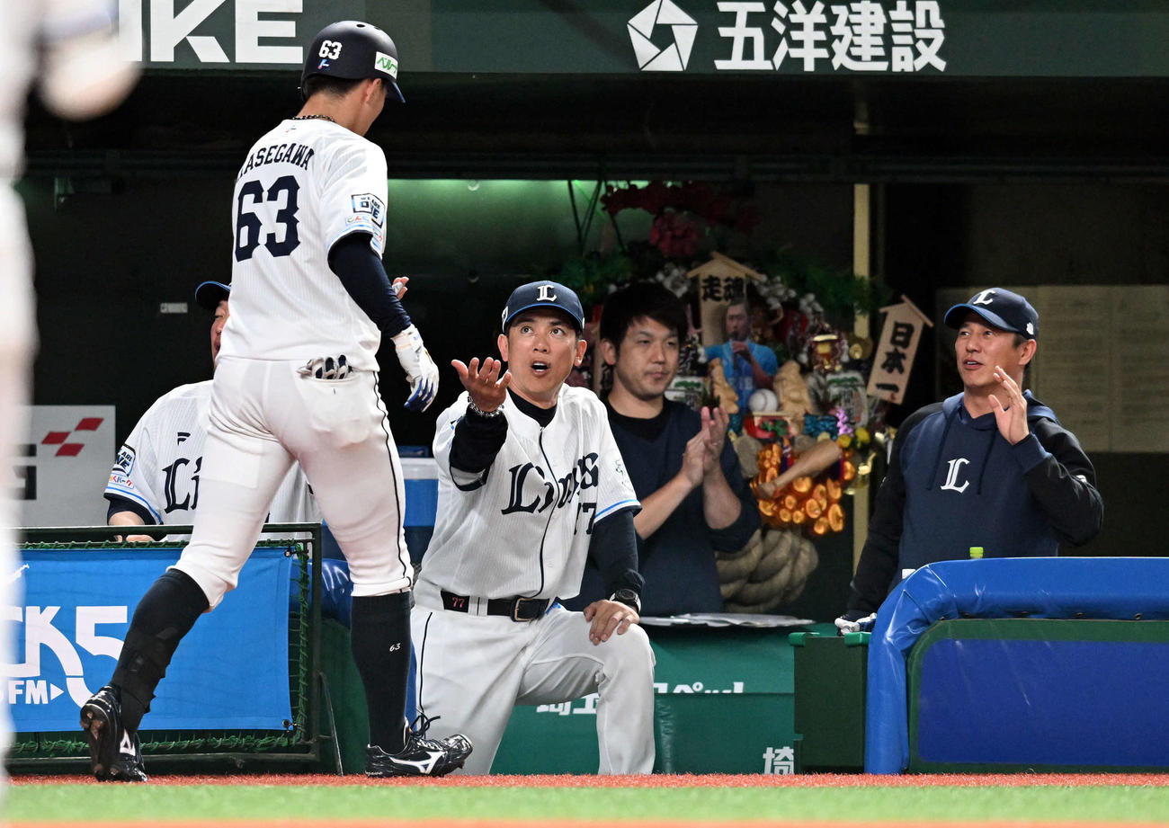 西武対ヤクルト　2回裏西武無死、同点のソロ本塁打を放った長谷川を迎える松井監督（撮影・たえ見朱実）