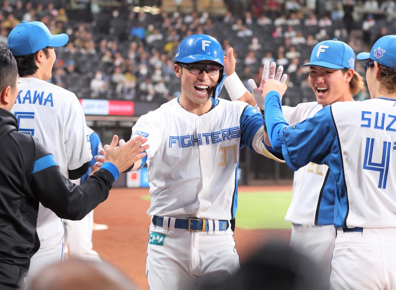 日本ハム対阪神　4回裏日本ハム2死、右越え本塁打を放ち出迎えられる江越（撮影・黒川智章）