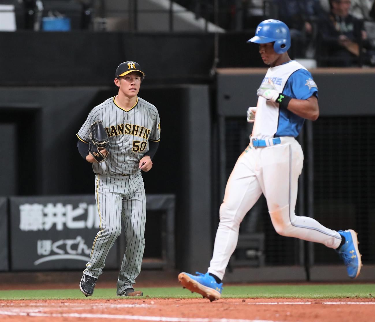 日本ハム対阪神　3回裏日本ハム2死一、二塁、マルティネスに適時二塁打を浴びる富田。右は生還する万波（撮影・黒川智章）