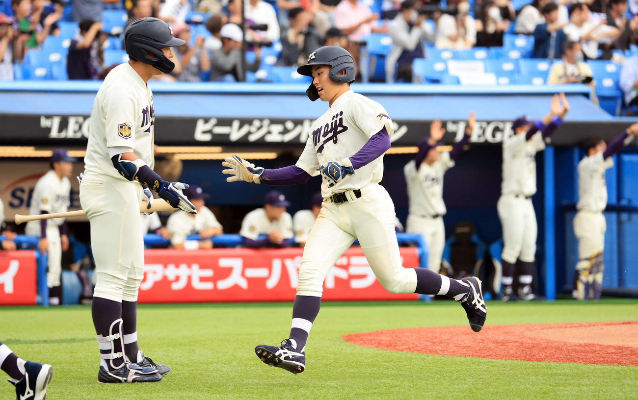 明大対白鴎大　9回表明大1死二塁、宗山の中越え適時二塁打で、喜ぶベンチを背に生還する飯森（撮影・浅見桂子）