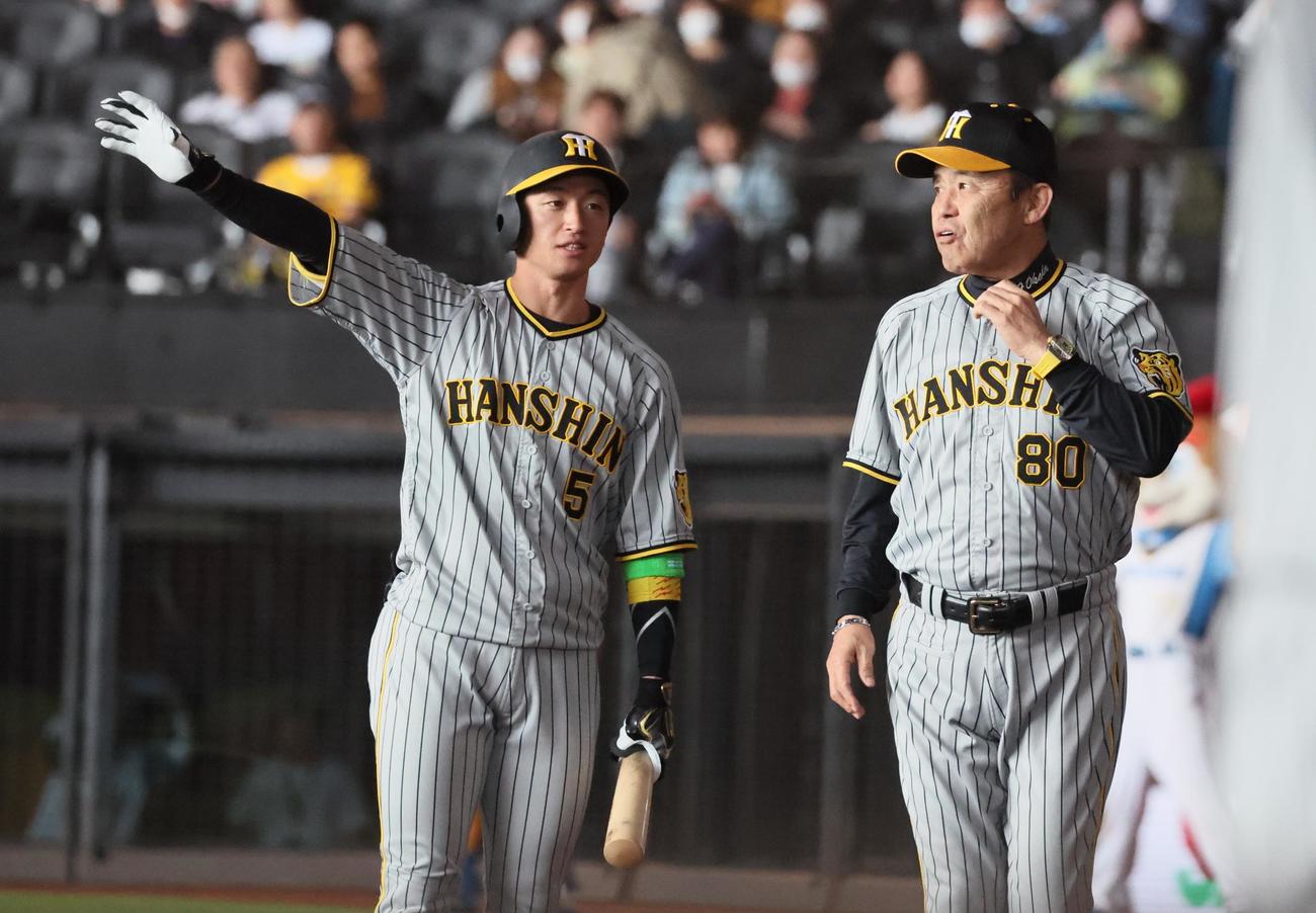 日本ハム対阪神　メンバー表交換を終え岡田彰布監督は近本（左）に声をかける（撮影・加藤