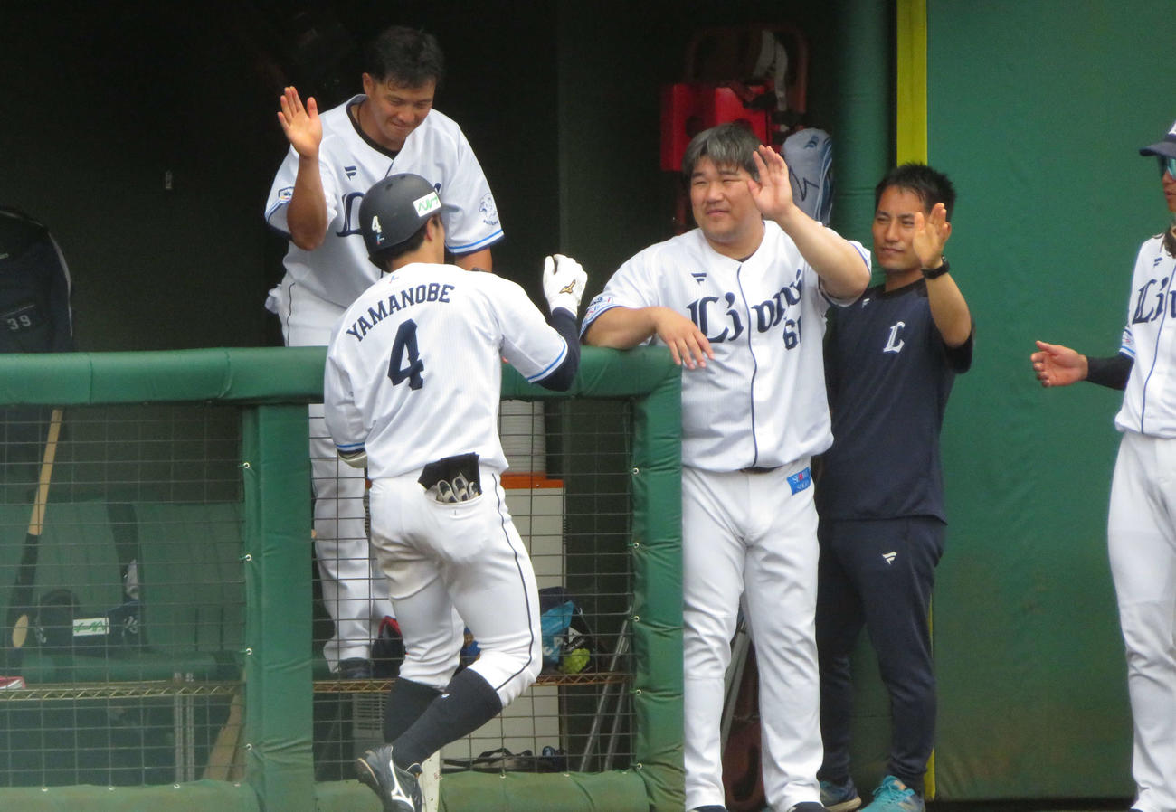 山野辺（手前左）の本塁打を笑顔で迎える西武中村（撮影・金子真仁）