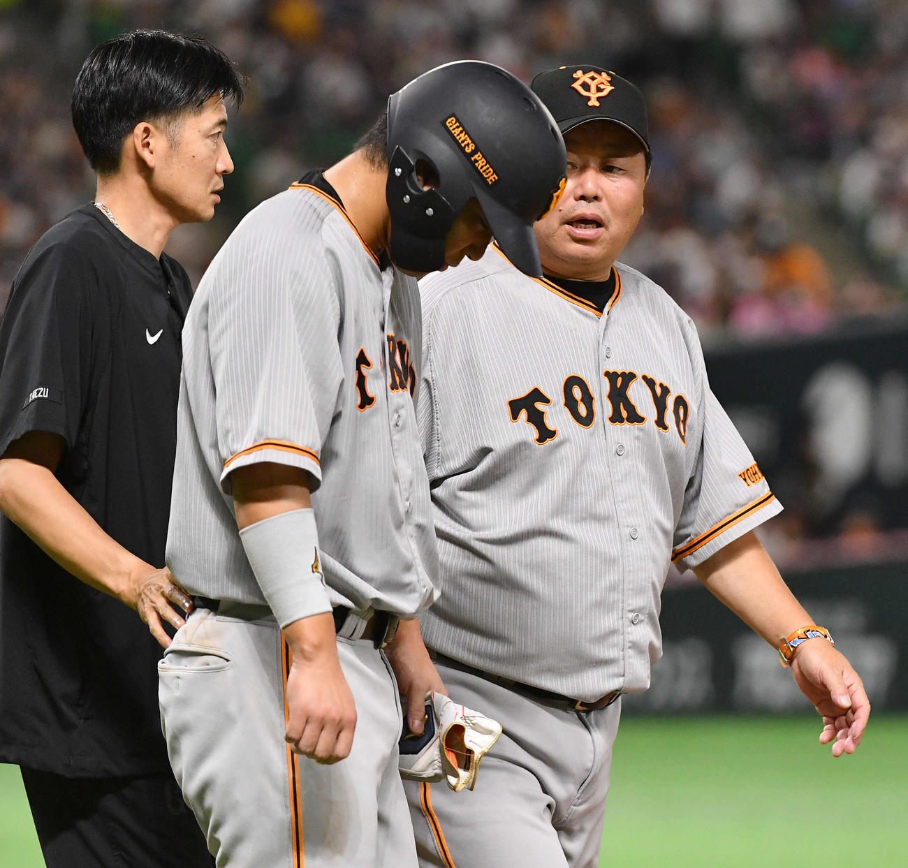 ソフトバンク対巨人　8回表巨人無死一塁、死球を受け、大久保コーチ（右）に声をかけられながら一塁へ向かう大城卓（撮影・岩下翔太）
