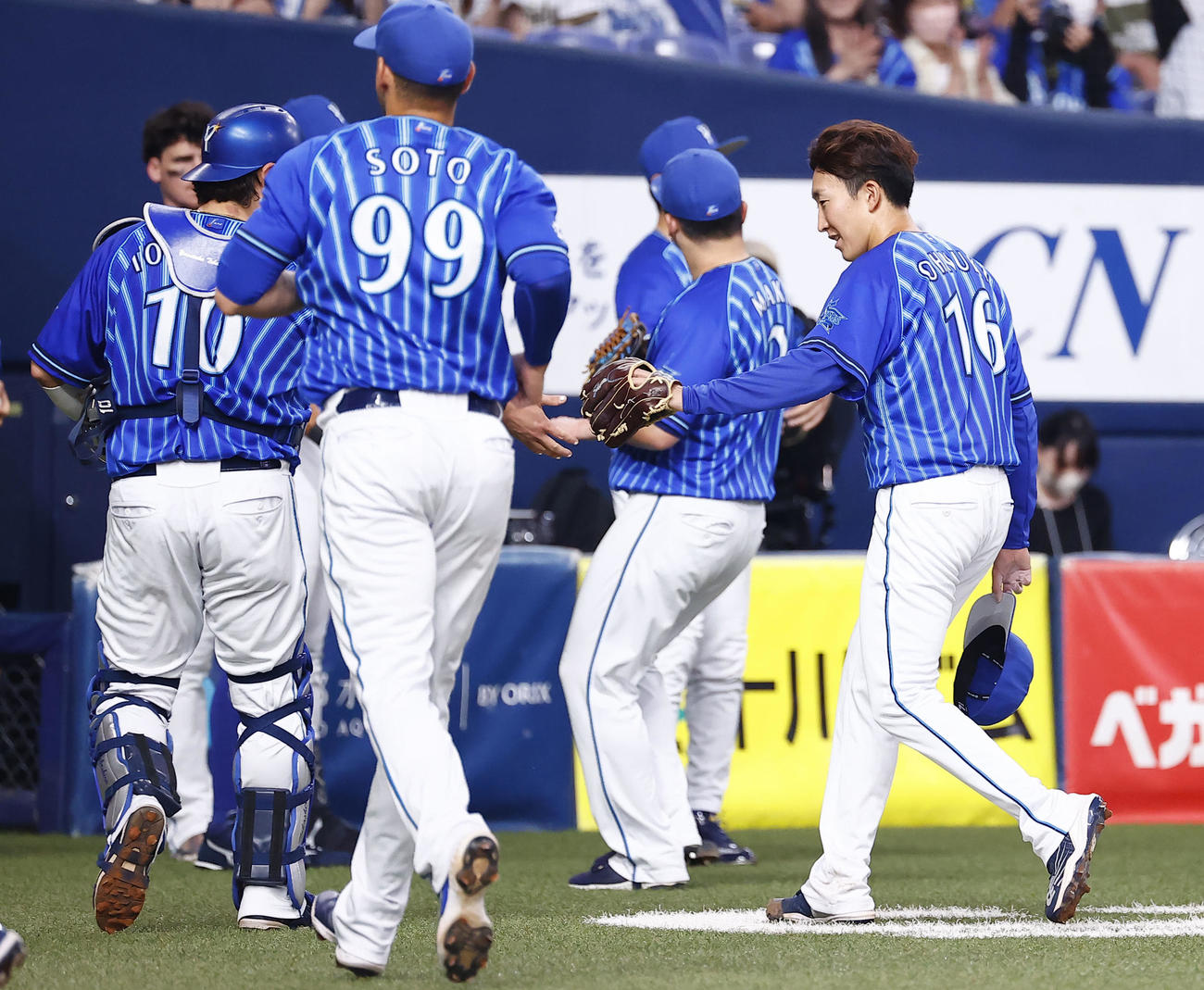 オリックス対DeNA 5回裏を終え戸柱恭孝（左端）とタッチを交わすDeNA大貫（右端）（撮影・藤尾明華）