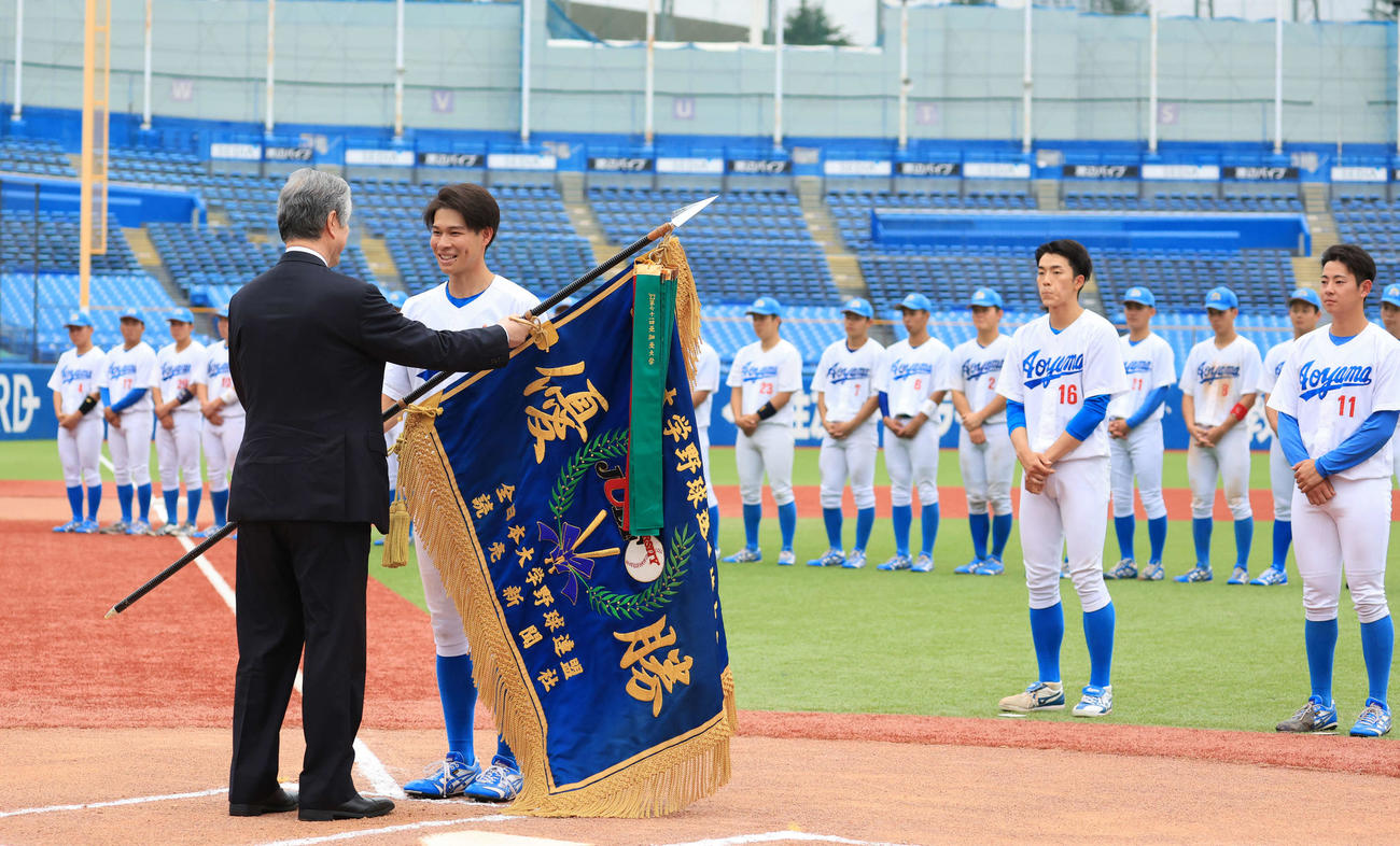 表彰式で、笑顔で優勝旗を受け取る青学大の中島主将（左から2人目）（撮影・浅見桂子）