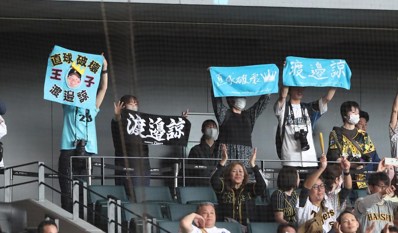 日本ハム対阪神　阪神、日本ハム両方のファンから応援グッズを掲げられる渡辺諒（撮影・黒川智章）