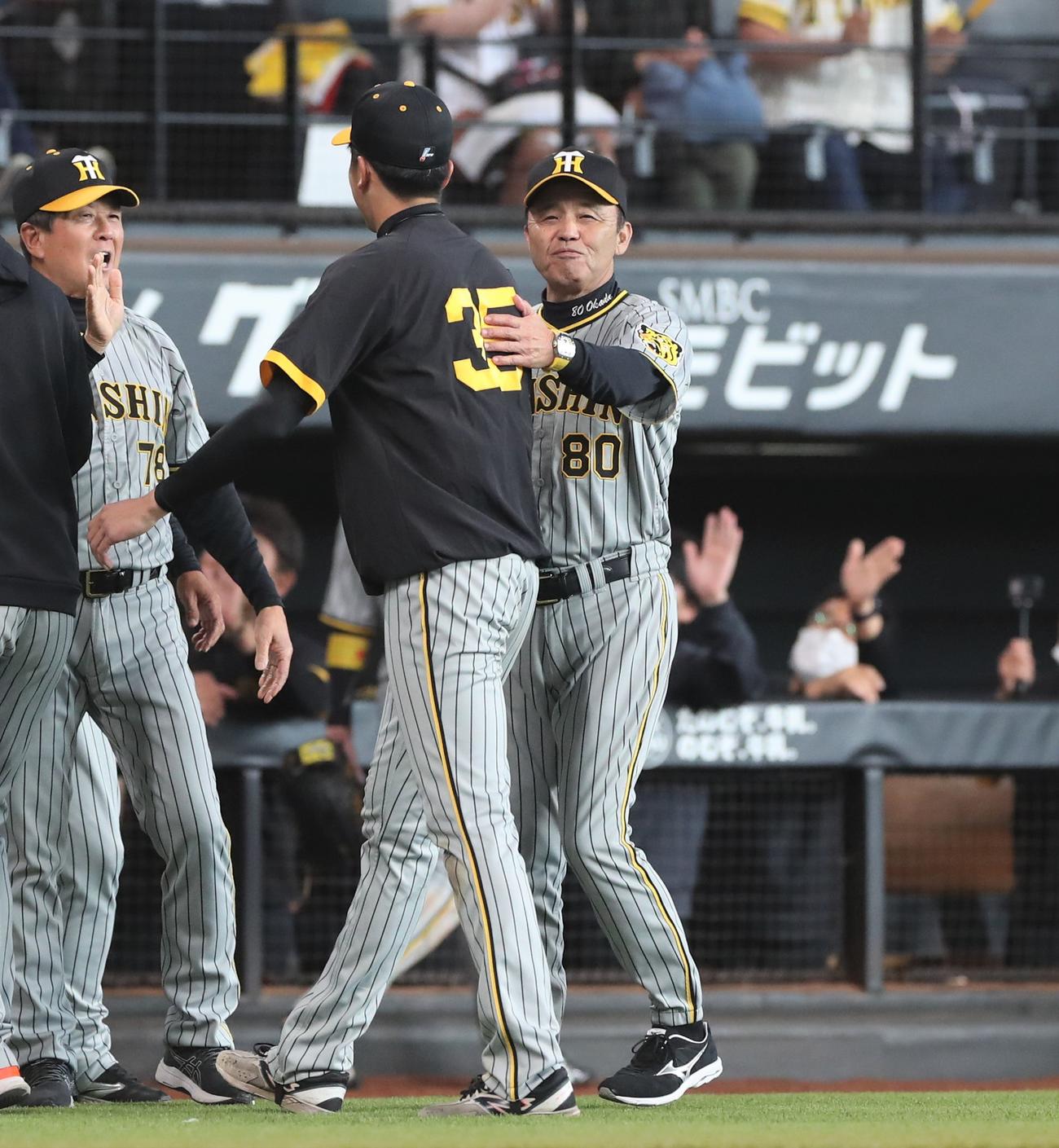 日本ハム対阪神　試合後、笑顔で才木の背中をたたく岡田監督（撮影・黒川智章）