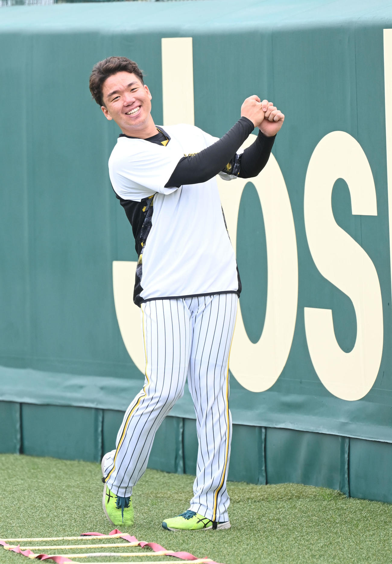 笑顔でウオームアップする阪神村上（撮影・和賀正仁）
