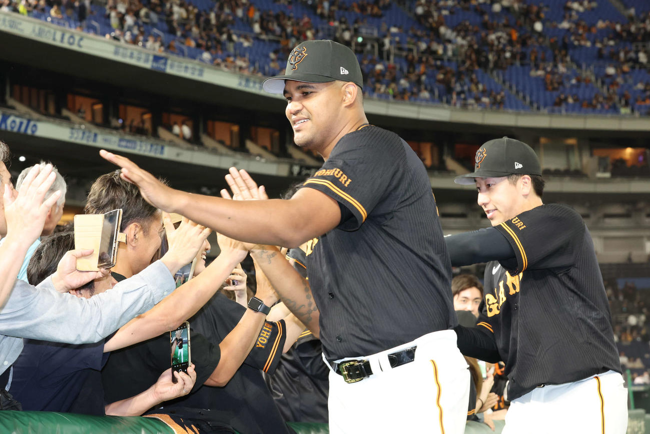 巨人対西武　勝利し、ファンとタッチを交わす巨人メンデス（左）と大勢（撮影・宮地輝）