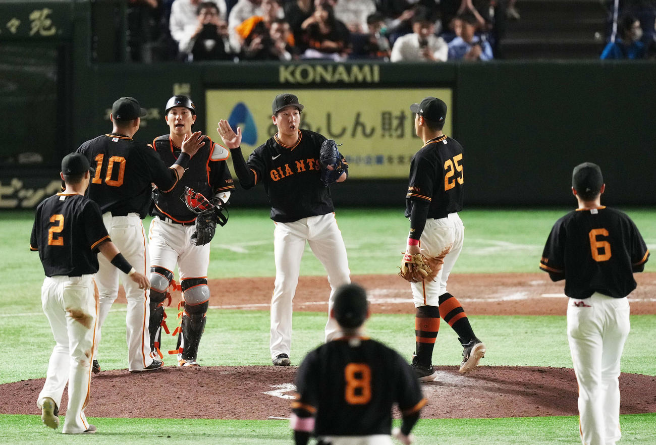 巨人対西武　西武に勝利し通算50セーブを達成しナインとタッチを交わす巨人大勢（中央）（撮影・横山健太）