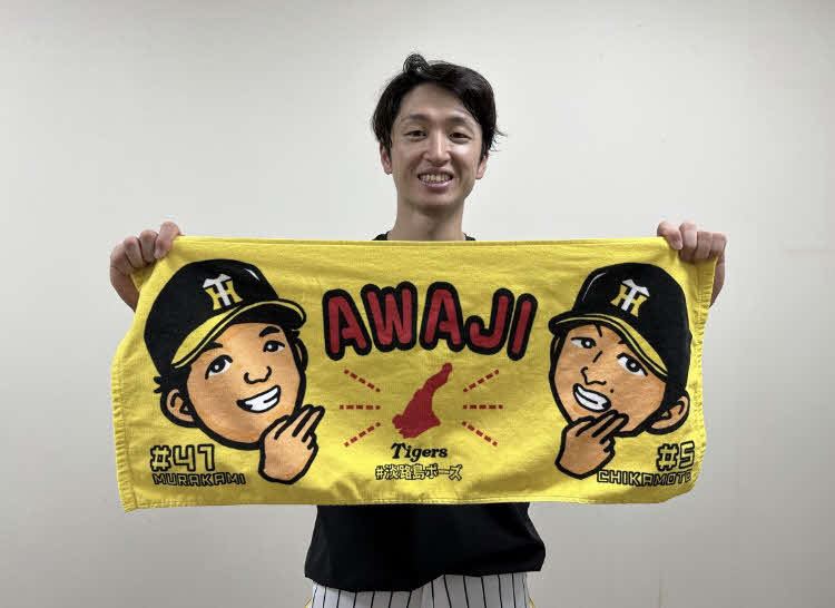 村上頌樹投手との「淡路島コンビ」グッズを掲げる、阪神近本光司外野手（球団提供）