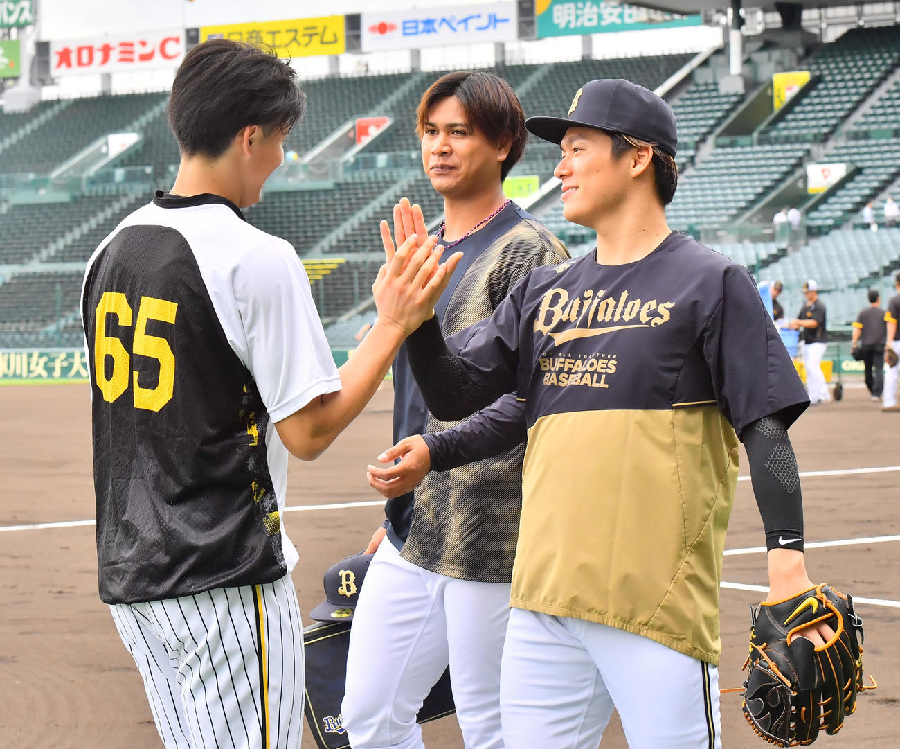 再会を果たしタッチする阪神湯浅（左）とオリックス山本、中央は宇田川（撮影・和賀正仁）