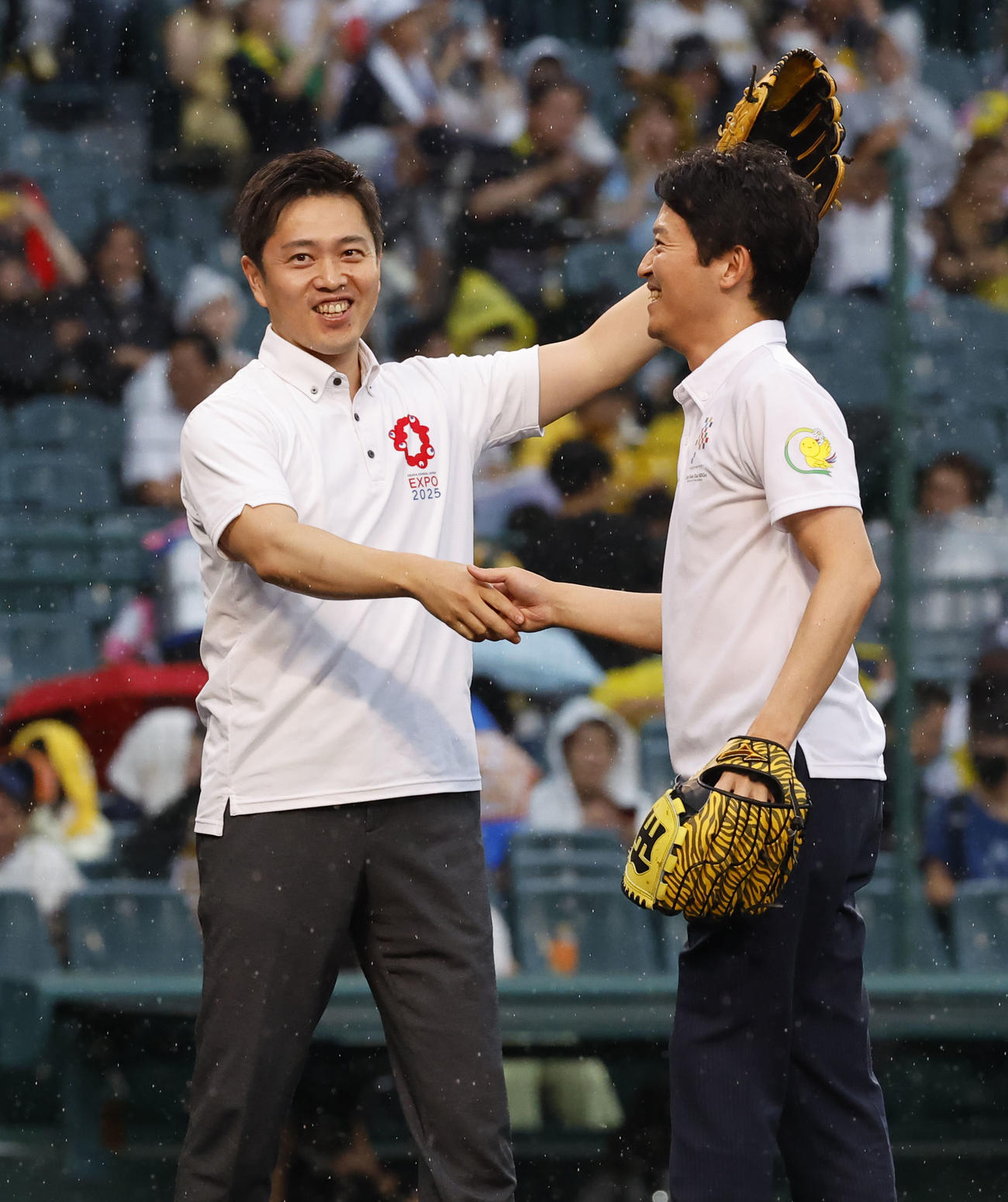 阪神対オリックス　ファーストピッチセレモニーを終え斎藤兵庫県知事（右）と握手を交わす吉村大阪府知事（撮影・藤尾明華）