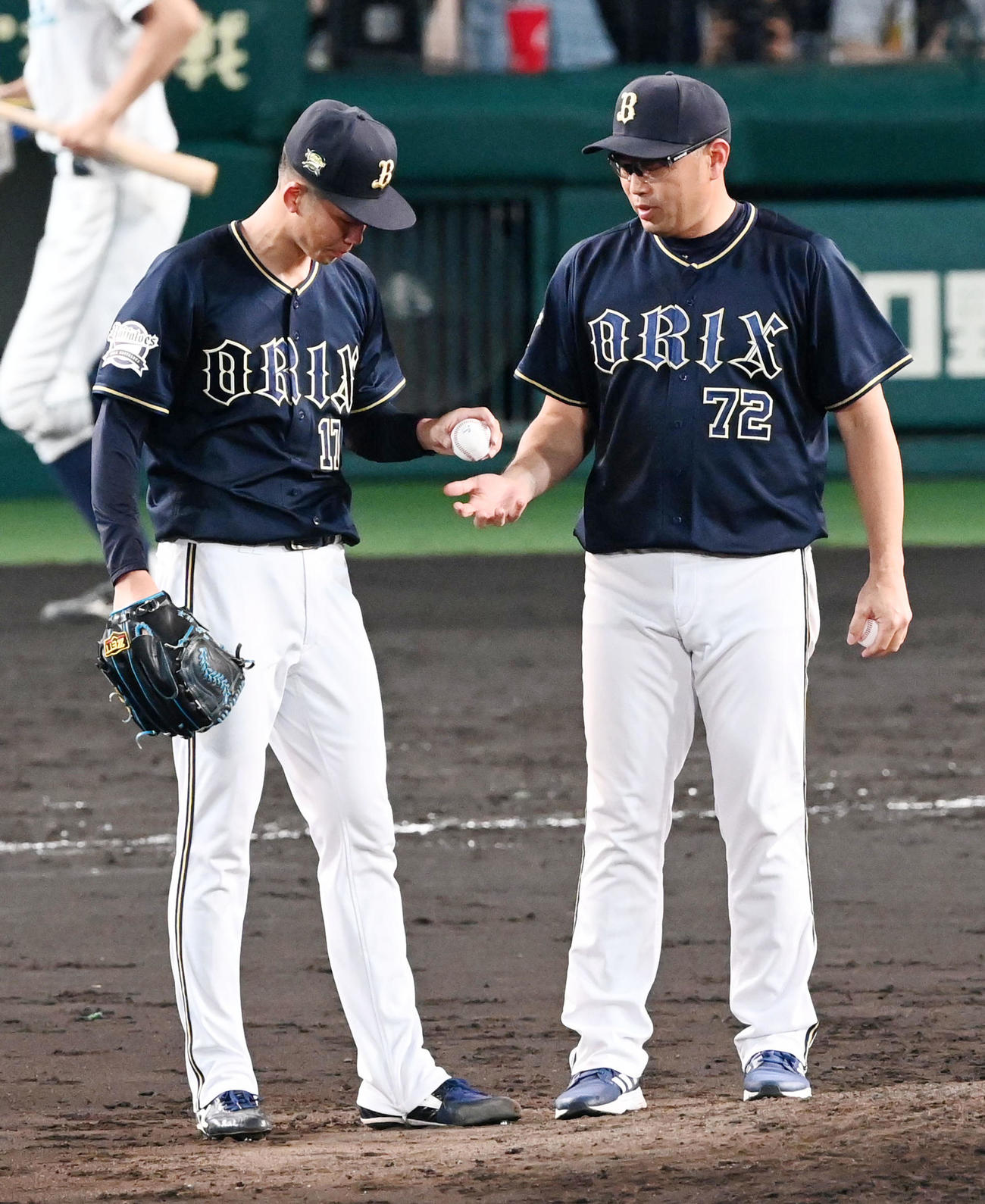 阪神対オリックス　4回裏阪神2死三塁、交代のオリックス曽谷（左）は平井コーチにボールを渡す（撮影・前岡正明）
