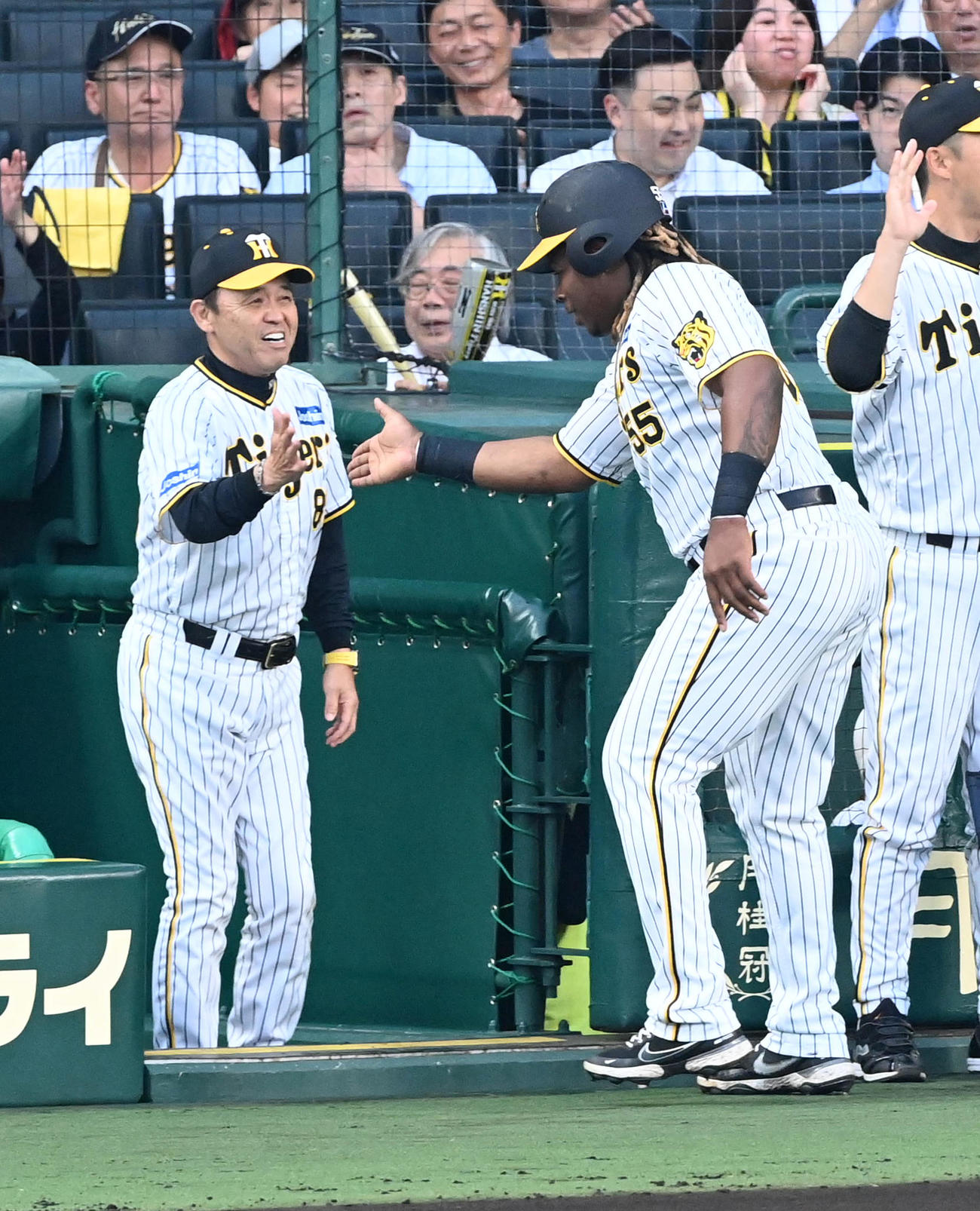 阪神対オリックス　1回裏阪神1死二、三塁、佐藤輝の適時2点二塁打で生還したミエセス（右）を笑顔で迎える阪神岡田監督（撮影・前岡正明）