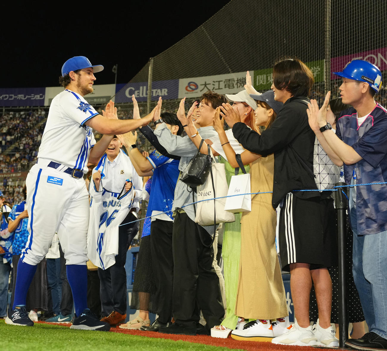 DeNA対日本ハム　試合後、ファンとタッチを交わすDeNAバウアー（左端）（撮影・江口和貴）