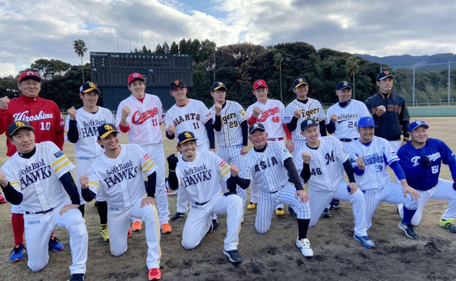 鹿児島・姶良市内での野球教室に参加し、「熱男」ポーズを見せる亜大・生田勉監督（中央）とソフトバンク松田宣浩（前列左から3番目）ら亜大OB（2021年12月18日）
