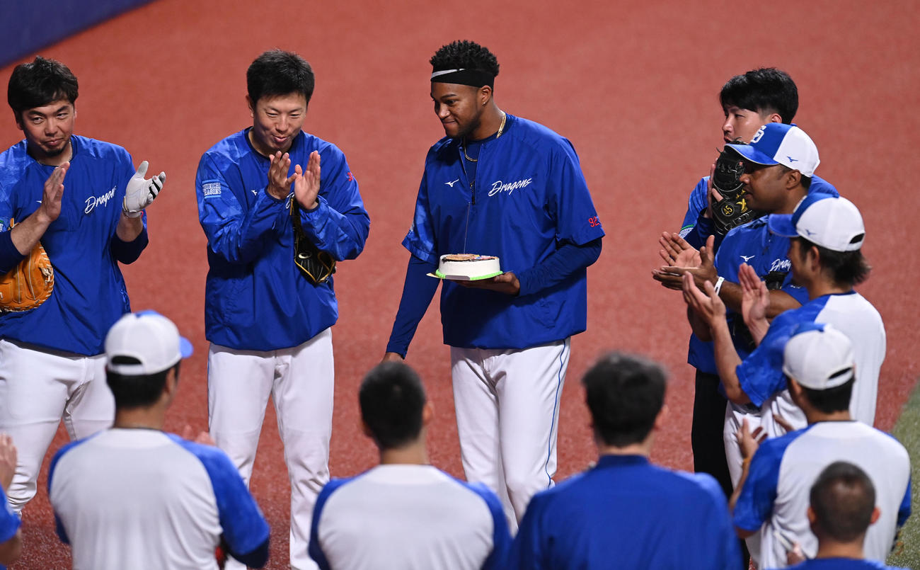 投手陣からNPB通算100セーブ達成を祝い贈られたケーキを手に笑顔の中日マルティネス（奥・中央）（2023年5月7日撮影）