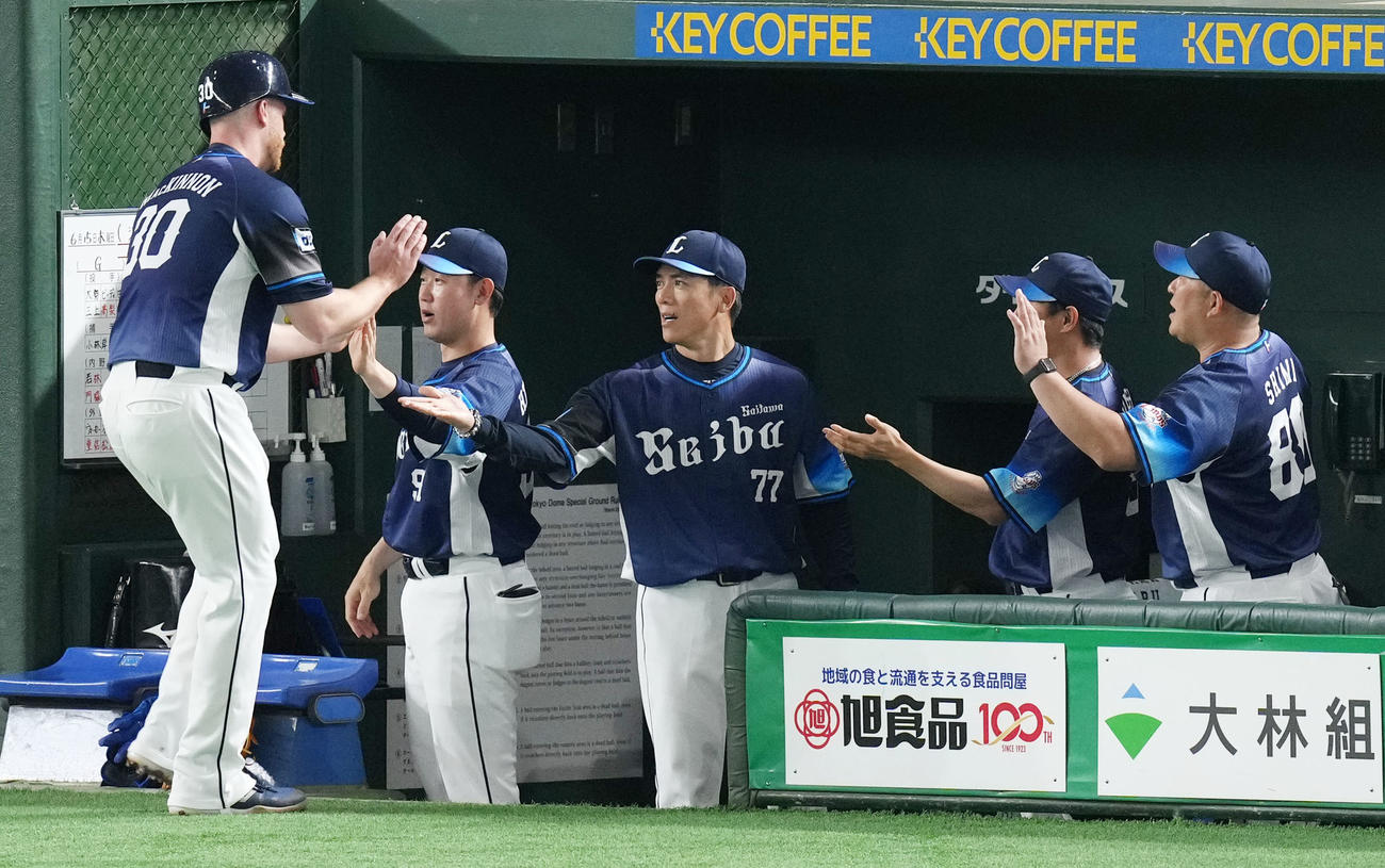 巨人対西武　2回表西武無死二、三塁、長谷川の右犠飛で生還したマキノン（左）とタッチを交わす松井監督（同3人目）（撮影・横山健太）