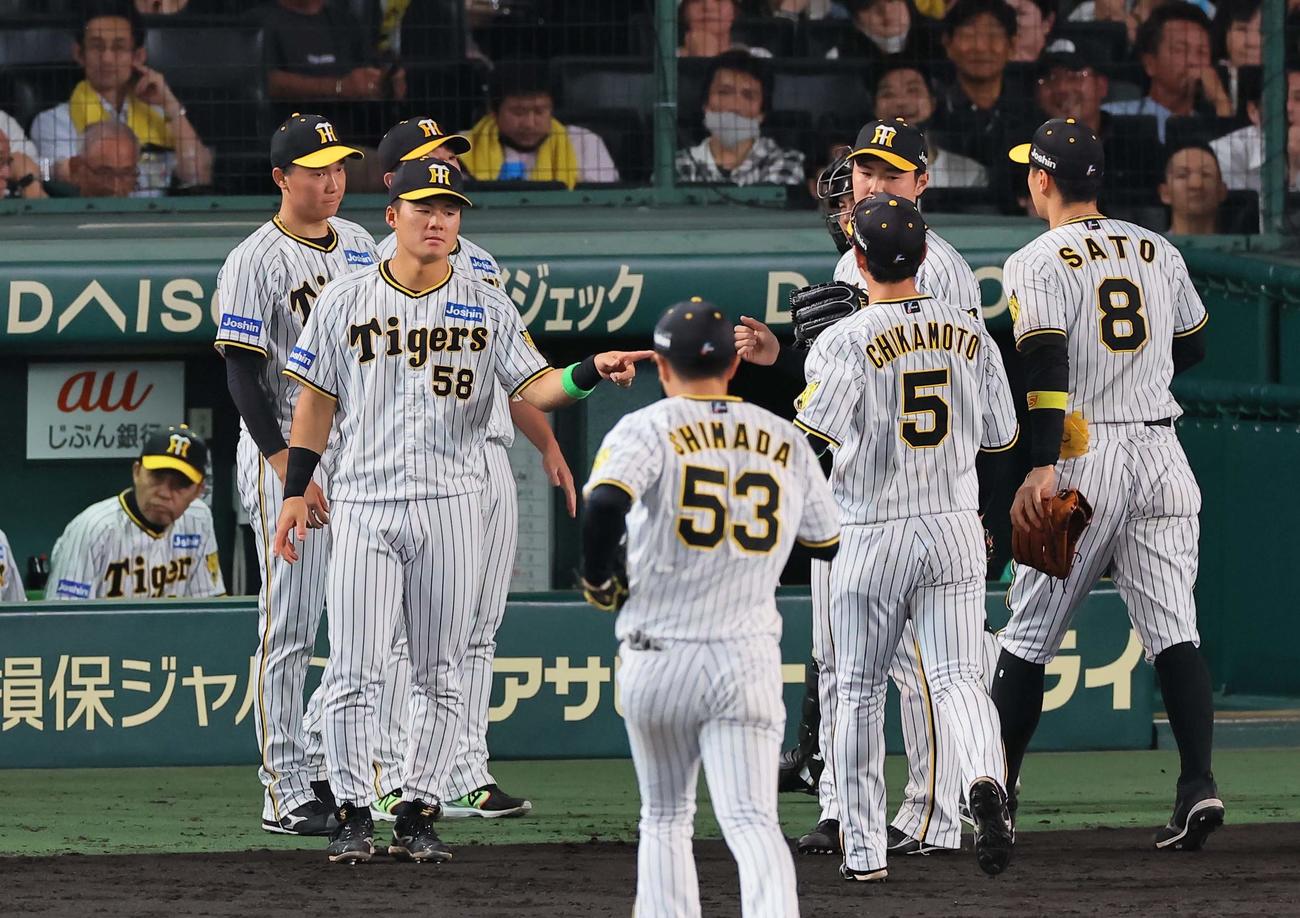 阪神対オリックス　9回降板した湯浅はベンチ前でナインを出迎える。左は岡田監督（撮影・上田博志）