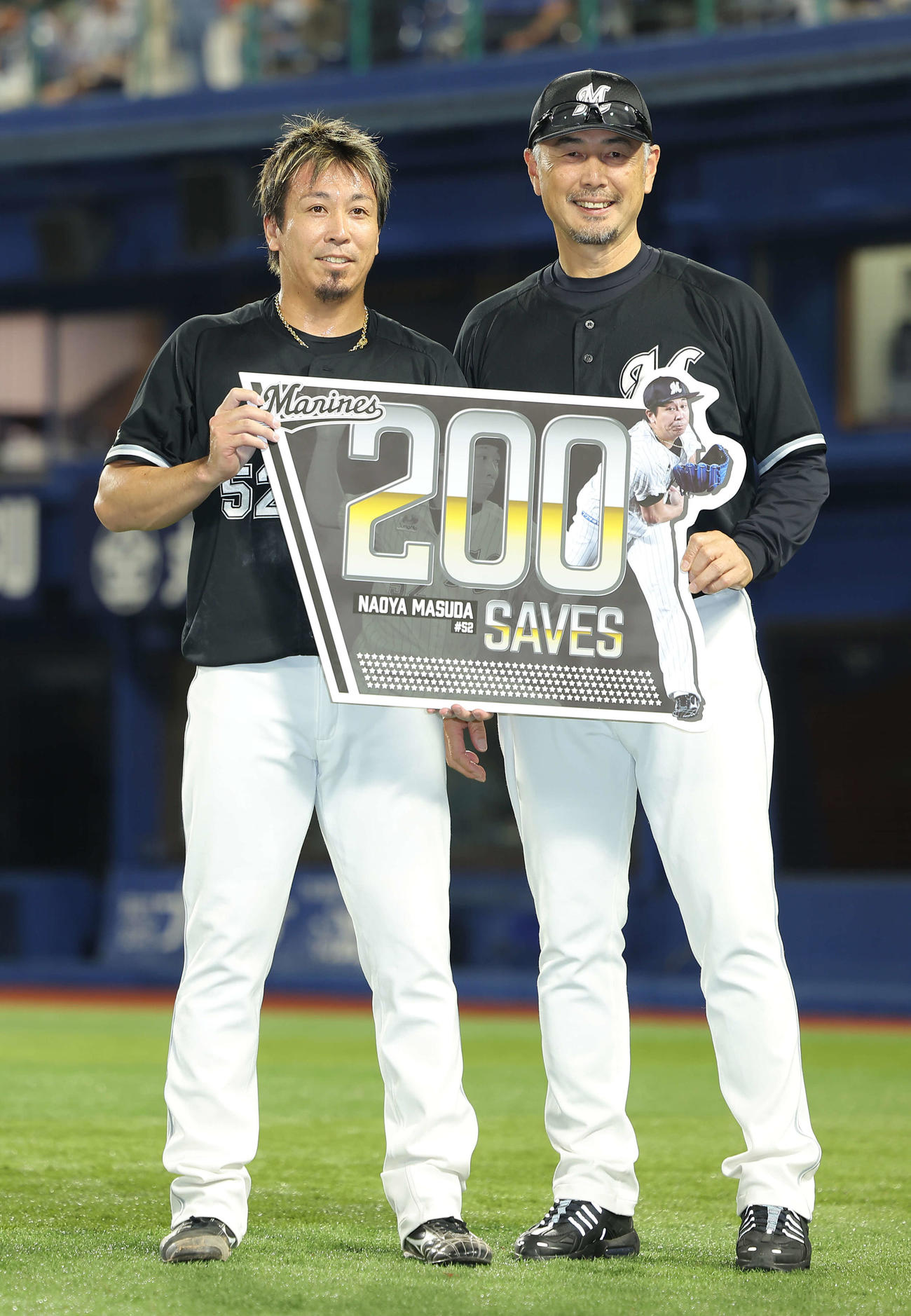 DeNA対ロッテ　DeNAに勝利し、200セーブを達成したロッテ益田（左）は、吉井監督と記念ボードを手に笑顔で写真に納まる（撮影・河田真司）