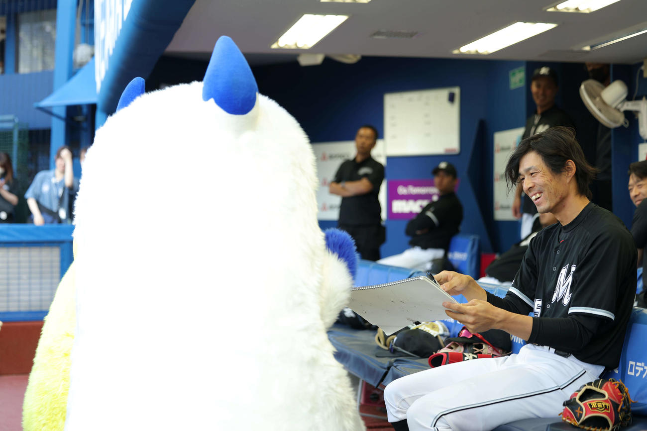 DeNA対ロッテ　試合前、ロッテ岡（右）に似顔絵をお願いするバート（撮影・河田真司）
