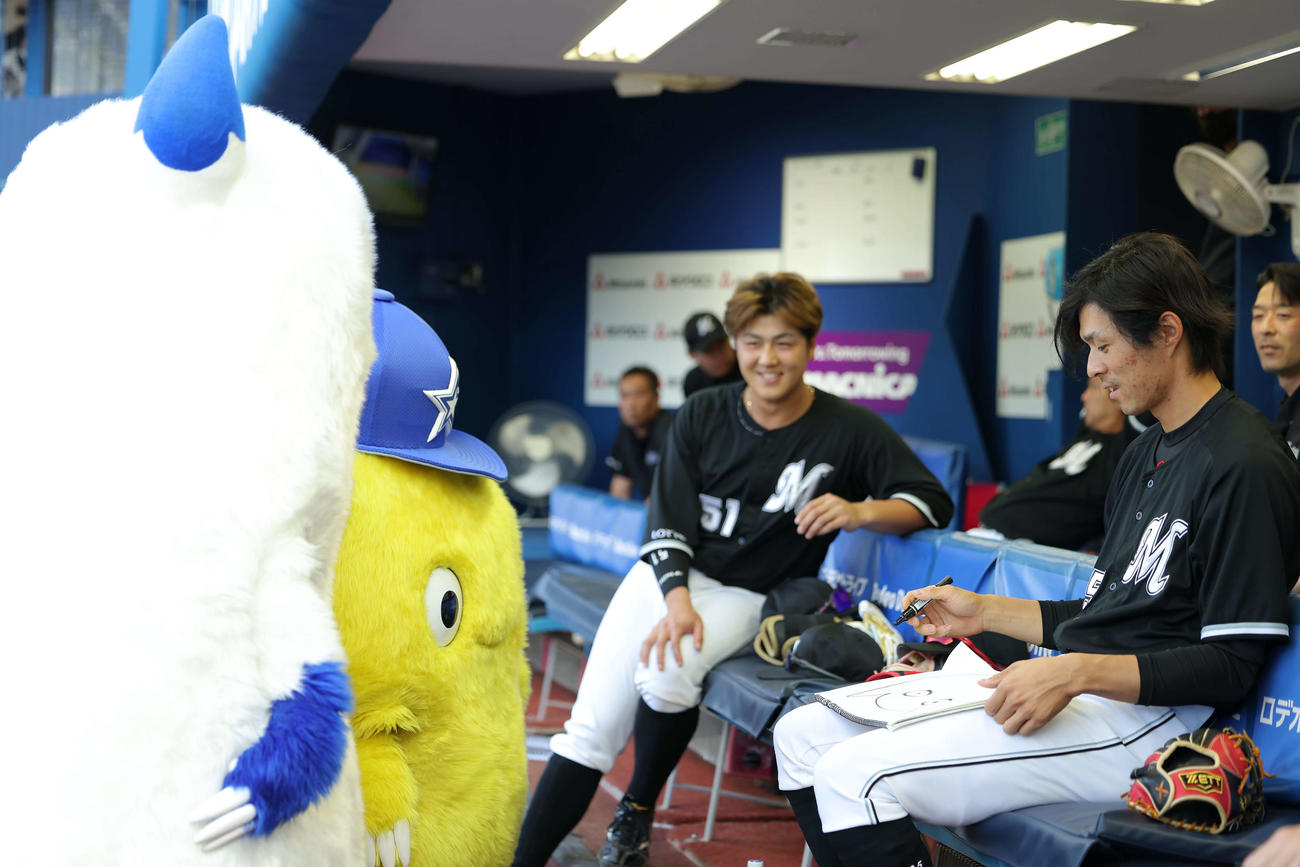 DeNA対ロッテ　試合前、ロッテ岡（右）に似顔絵をお願いするバート（撮影・河田真司）