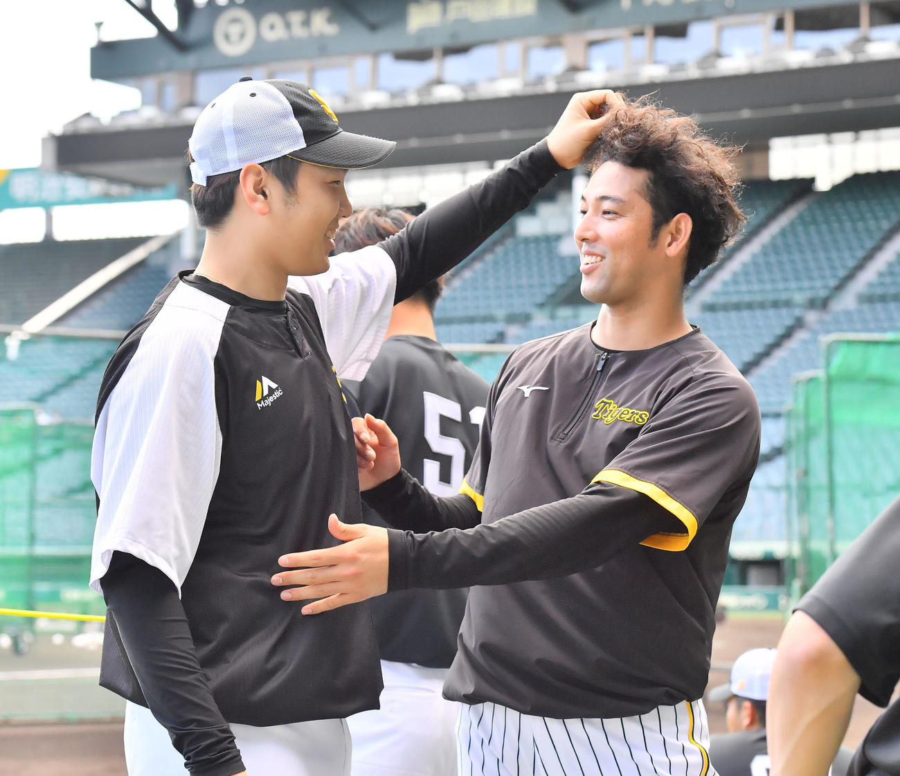 阪神対ソフトバンク　ソフトバンク石川（左）から髪型をいじられる阪神加治屋（撮影・和賀正仁）