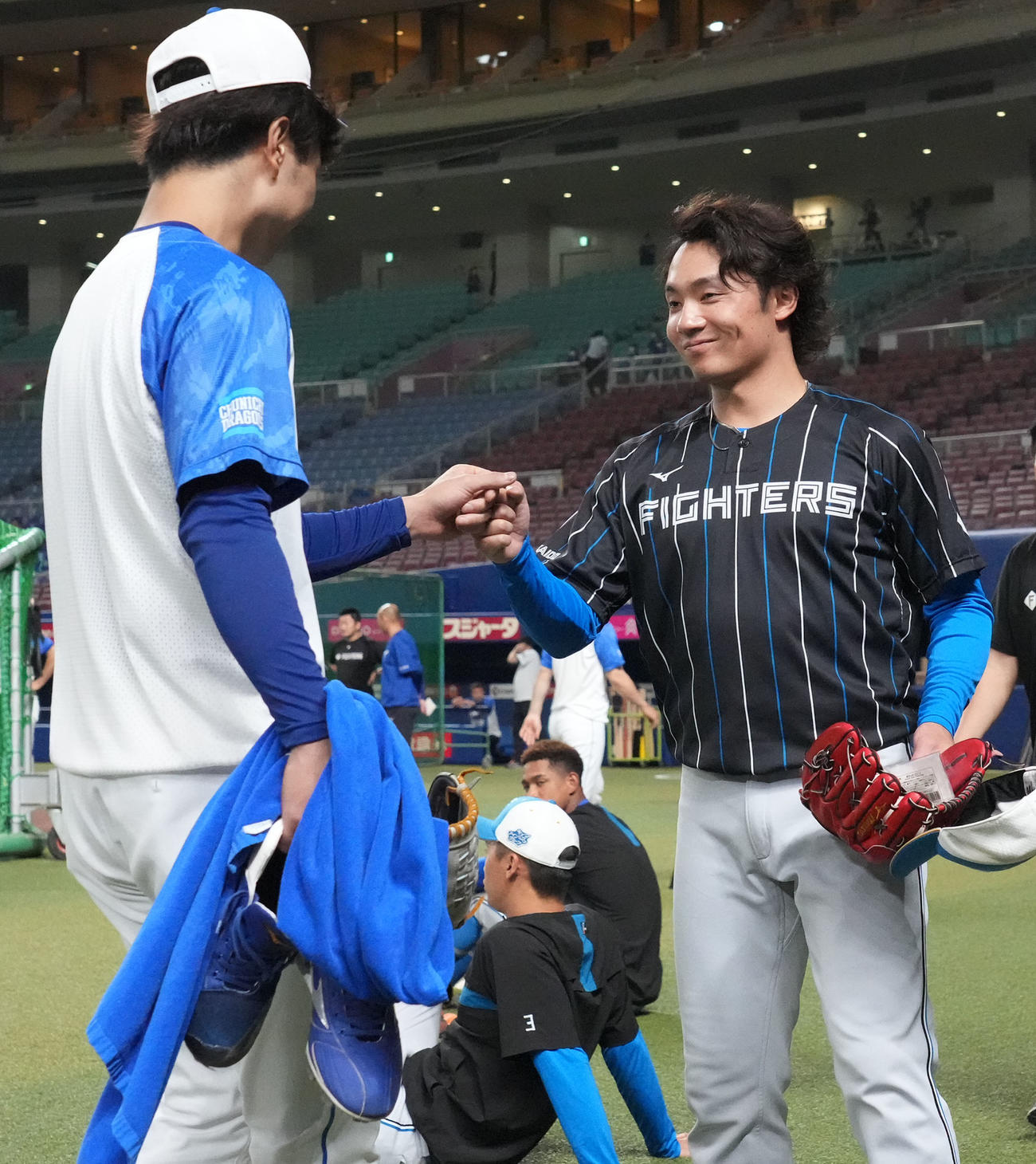 中日対日本ハム　試合前、高橋宏とタッチを交わす伊藤（右）（撮影・森本幸一）