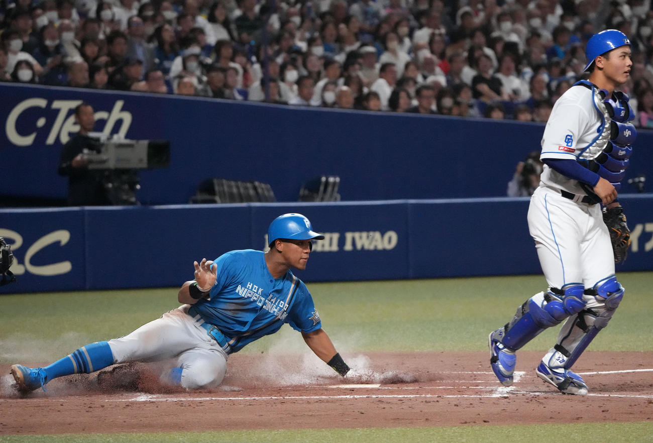 中日対日本ハム　4回表日本ハム2死一、三塁、一走が一、二塁間で挟まれる間に三塁から生還する万波（左）捕手は石橋（撮影・森本幸一）