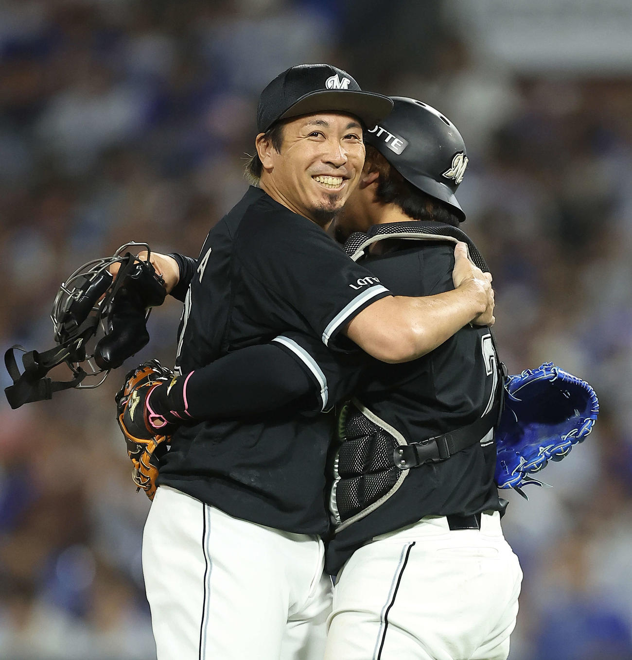 DeNA対ロッテ　200セーブを達成したロッテ益田（左）は田村に迎えられ笑顔を見せる（撮影・河田真司）