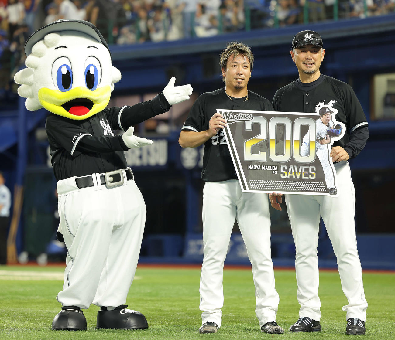 DeNA対ロッテ　200セーブを達成したロッテ益田（左）は、吉井監督と記念ボードを手に笑顔で写真に納まる（撮影・河田真司）
