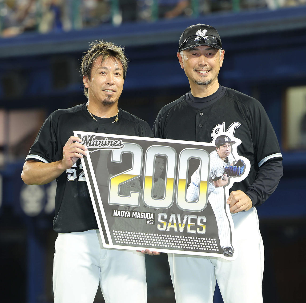 DeNA対ロッテ　DeNAに勝利し、200セーブを達成したロッテ益田（左）は、吉井監督と記念ボードを手に笑顔で写真に納まる（撮影・河田真司）