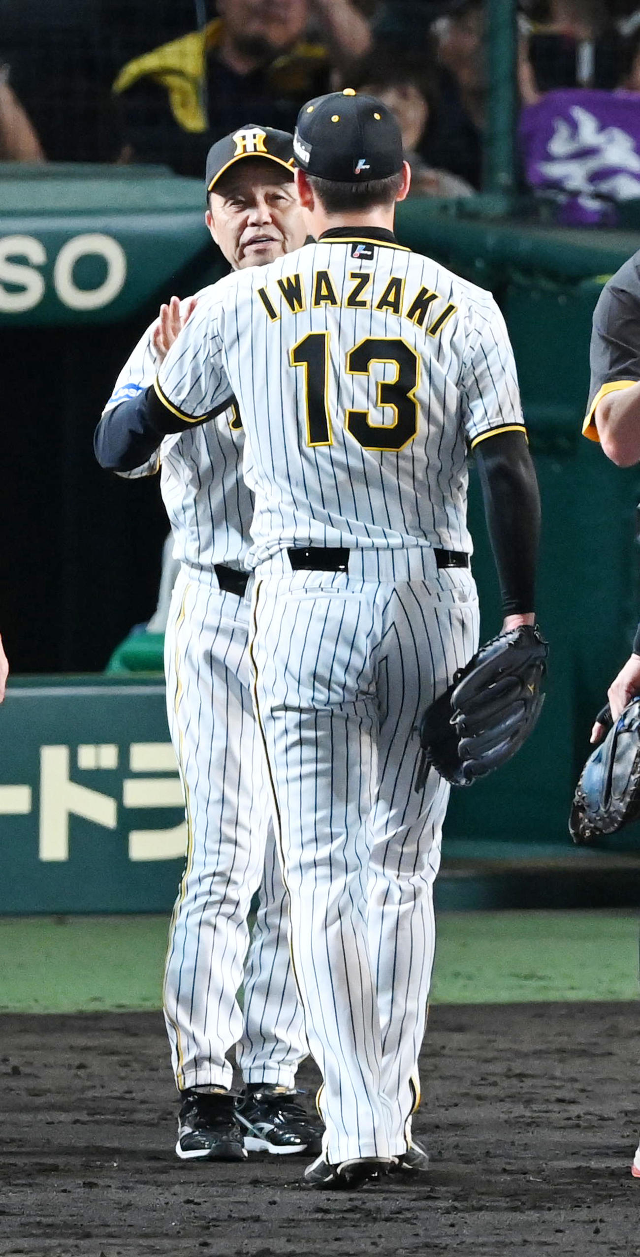 阪神対ソフトバンク　岩崎（背中）を迎える岡田監督（撮影・前岡正明）