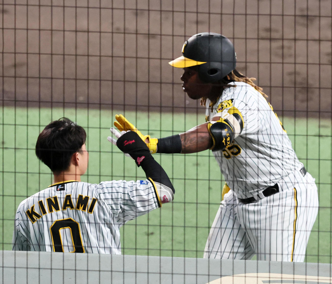 阪神対ソフトバンク　4回裏阪神1死満塁、ミエセスは右犠飛を打ち上げてベンチへ戻りナインとタッチする（撮影・加藤哉）
